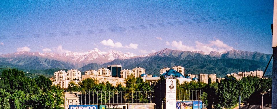 A panoramic view of the Tien Shan mountain range and the city of Almaty in summer